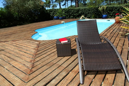 View of long chairs set by swimming pool